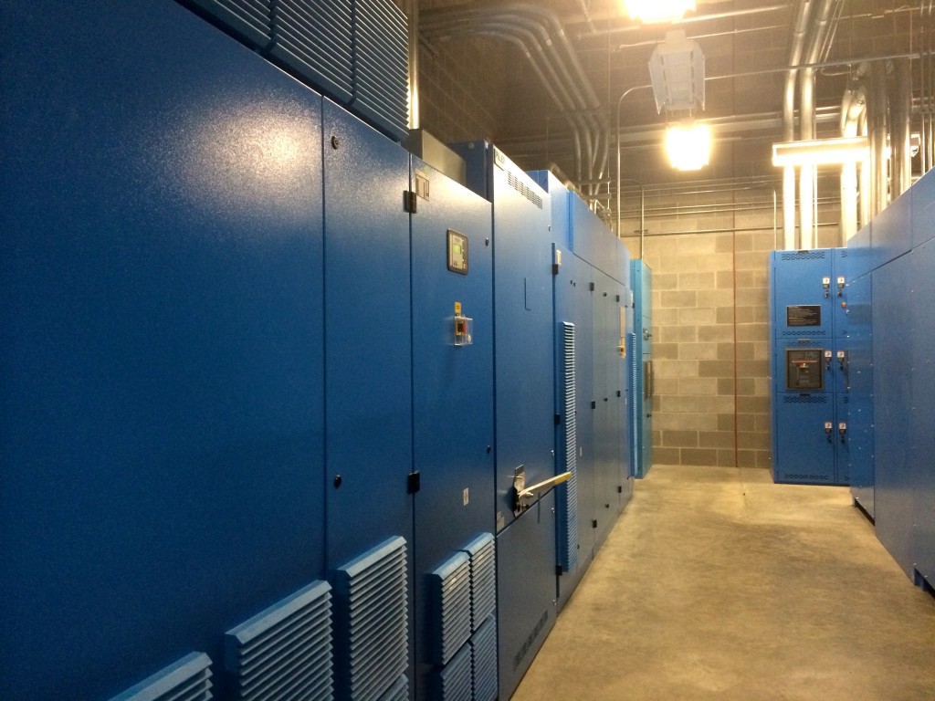 Here's a look into the flywheel room. The flywheels in these boxes spin 24x7 whenever the main power is on. If the power suddenly gets cut, they'll continue to spin a generator, providing power to the servers for about 20 seconds. This gives the generators time to start up, since they take about 9 seconds to get going.